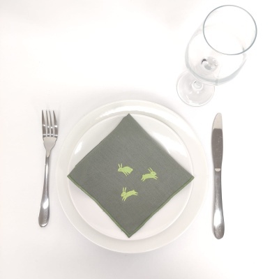 Conjunto de mesa com prato, guardanapo verde com coelhos, talheres e taça