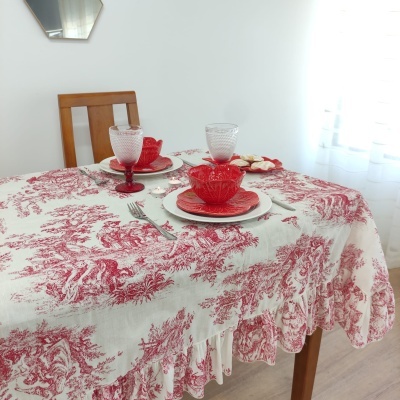 Mesa posta com toalha branca e vermelha, pratos e copos cor de rosa
