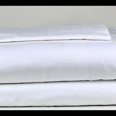 Conjunto de roupa de cama branca dobrada em superfície plana