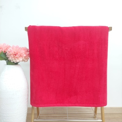 Toalha vermelha macia pendurada em suporte de madeira