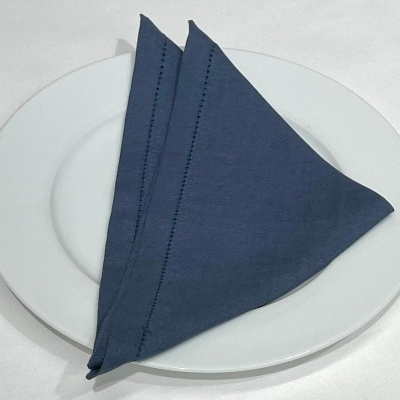 Guardanapo azul escuro em tecido sobre prato branco