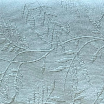 Tecido branco com padrão em relevo de folhas e ramos