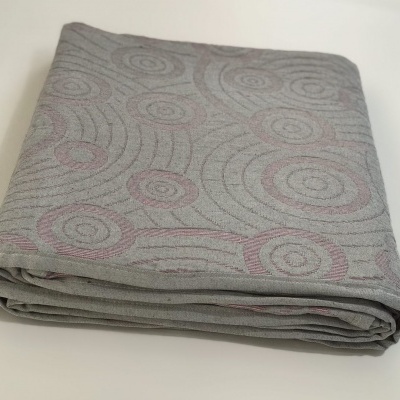 Tecido cinzento com padrão rosa de círculos concêntricos dobrado