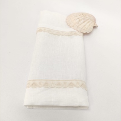 Toalha branca de linho com bordas bege e concha em cima