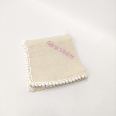 Fralda de tecido bege com bordado rosa e renda branca