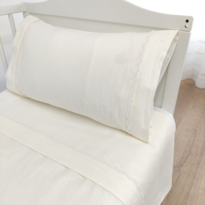 Travesseiro branco com fronha rendada em suporte branco