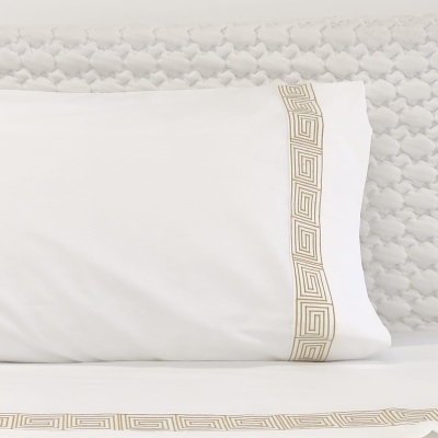 Roupas de cama brancas com bordados geométricos dourados