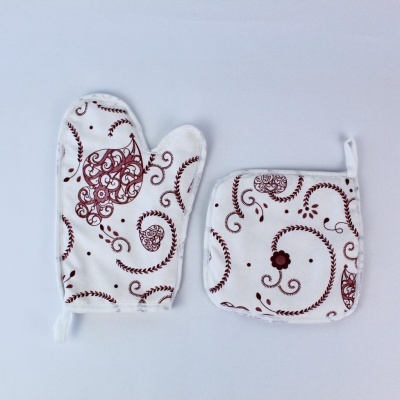 Luvas e descanso de panela em tecido branco com padrões castanhos