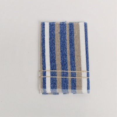 Guardanapo de tecido riscado azul, bege e branco dobrado sobre fundo branco