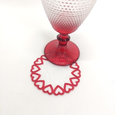 Copo de vidro vermelho com suporte branco bordado com corações vermelhos