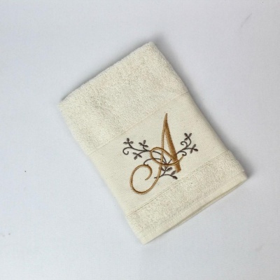 Toalha branca com bordado dourado e preto