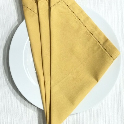 Guardanapo amarelo dobrado sobre prato branco