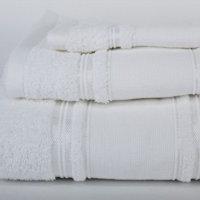 Toalhas brancas de algodão empilhadas com faixas decorativas