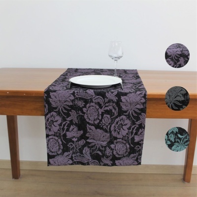 Caminho de mesa com padrão floral em várias cores sobre mesa de madeira