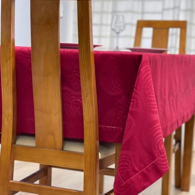 Mesa de madeira com toalha de mesa vermelha e cadeiras de madeira clara