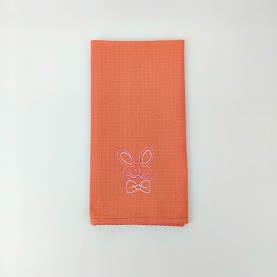 Toalha laranja com bordado branco de coelho