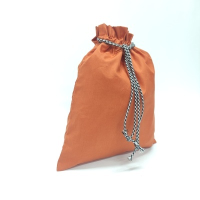 Saco de tecido laranja com cordão preto e branco