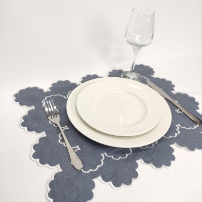 Conjunto de pratos e talheres com base de tecido cinzento e copo de vidro