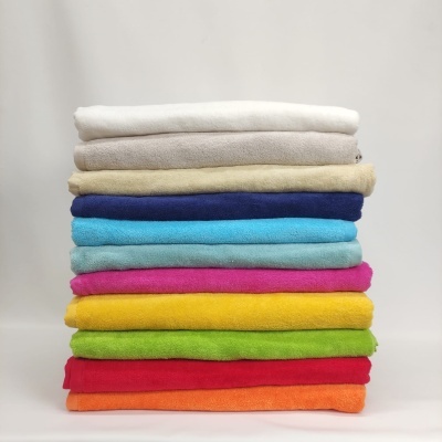 Pilhas de toalhas coloridas dobradas sobre fundo branco