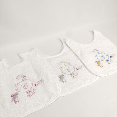 Três babetes brancos com bordados de animais, em fila sobre fundo branco