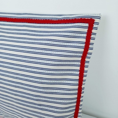 Capa de almofada branca com riscas azuis e borda vermelha