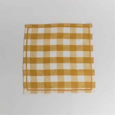 Guardanapo amarelo mostarda e branco com padrão de quadrados