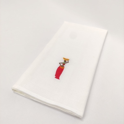 Guardanapo branco com bordado colorido de mulher a carregar jarro na cabeça