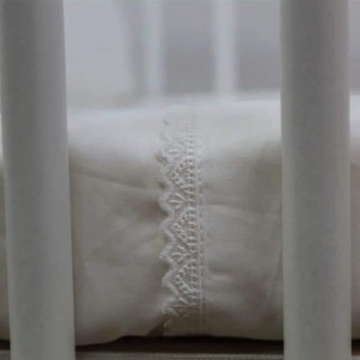 Almofada branca com renda vista através de barras brancas