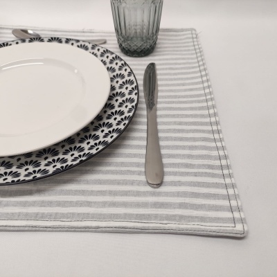 Conjunto de pratos, faca, copo e guardanapo à mesa