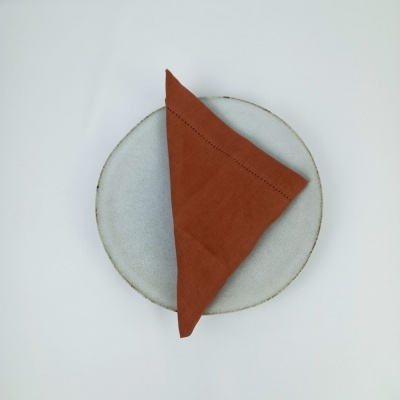 Prato redondo cinza claro com guardanapo laranja triangular