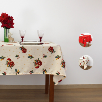 Toalha de mesa natalícia bege com estampas vermelhas e verdes numa mesa de madeira