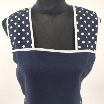 Blusa azul com bolinhas brancas e acabamento branco em manequim preto