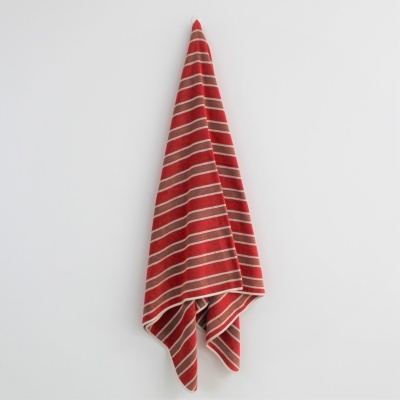 Toalha de tecido com riscas vermelhas e bege pendurada