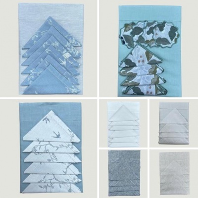 Guardanapos decorativos em tecido azul, branco e cinza com padrões variados