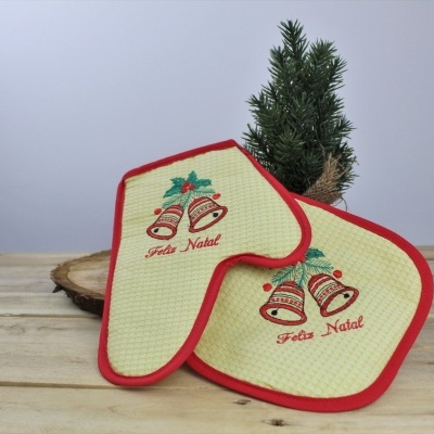 Utensílios de cozinha de Natal com decoração de sinos e bordas vermelhas na superfície de madeira.