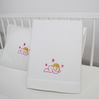 Toalhas de bebé brancas com bordado de anjo cor-de-rosa e amarelo num berço branco