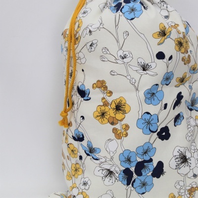 Mochila saco com padrão floral azul e amarelo e cordão amarelo