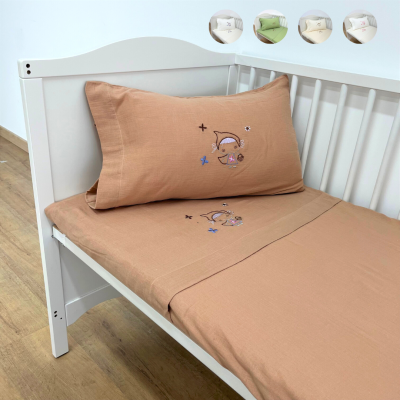 Cama branca de bebé com roupa de cama em tom pele e bordado infantil