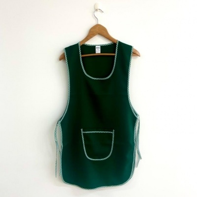 Avental verde escuro com costuras brancas pendurado em cabide