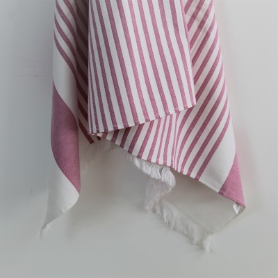 Toalha de tecido com riscas cor-de-rosa e brancas pendurada com franjas