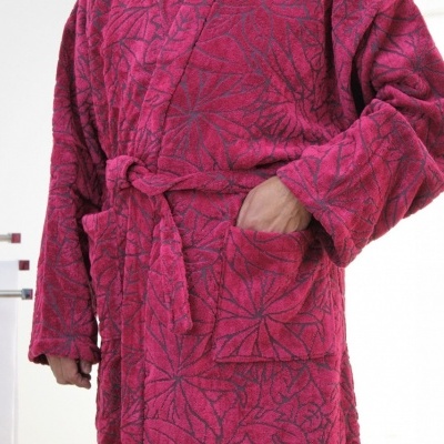 Robe felpudo rosa com padrões e bolso no ambiente interior.