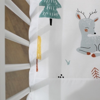 Colchão branco com estampa de cervo e árvore em cama branca