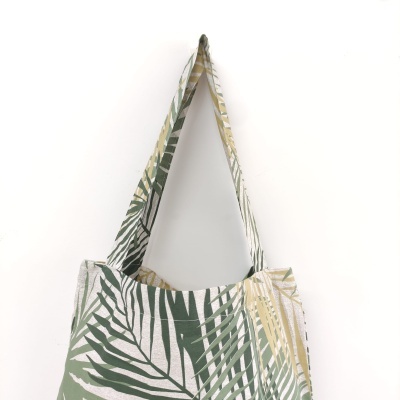 Sacola de tecido com padrão de folhas em verde, bege e branco
