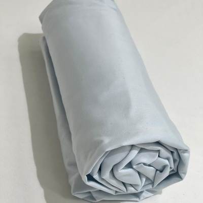 tecido azul claro enrolado sobre superfície branca