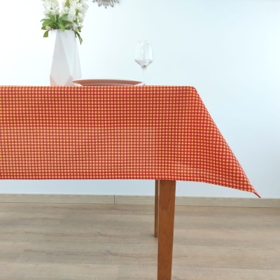 Toalha de mesa xadrez vermelha e branca sobre mesa de madeira, com prato, copo e vaso com flores