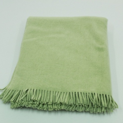 Lenço verde claro com franjas sobre superfície branca
