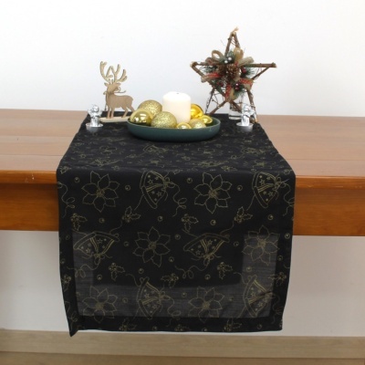 Toalha de mesa preta com padrão dourado e decoração de Natal em mesa de madeira