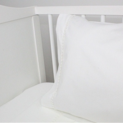 Berço branco com colchão e almofada brancos