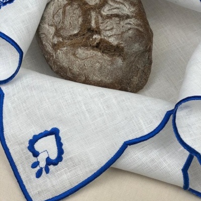 Pão rústico sobre tecido branco com bordado azul