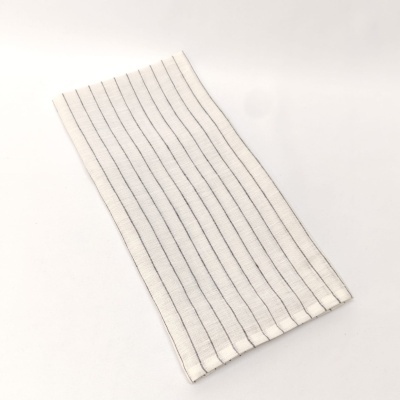 Toalha branca com riscas pretas finas dobrada sobre fundo branco